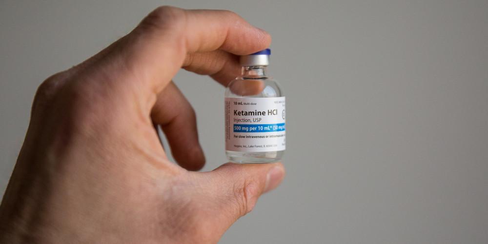 Someone holding a bottle of Ketamine HCl injection received in Chicago for IV therapy.