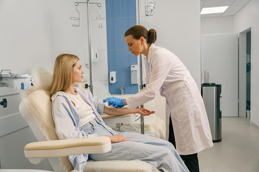A medical professional administering ketamine therapy to a patient in a clinical setting.